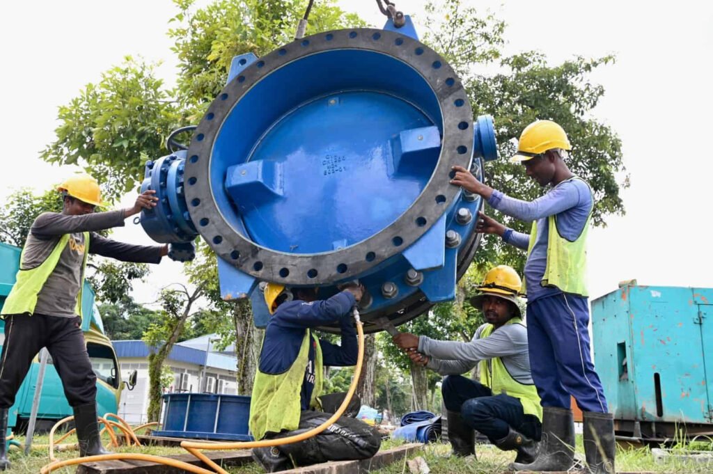 CWG engineers installing a large valve on a water treatment line